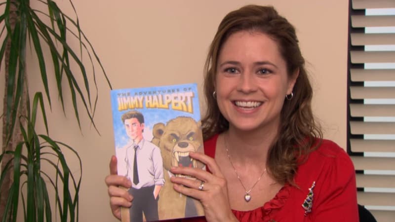 Pam from The Office holding the hand-drawn comic book 'The Adventures of Jimmy Halpert'
