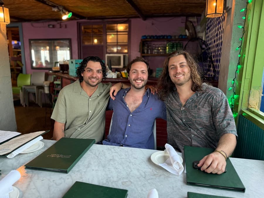 Photo: three friends smiling at a restaurant table